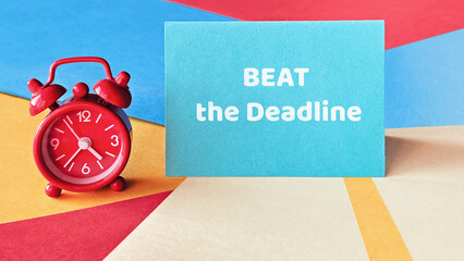 Red alarm clock and blue card with text BEAT the Deadline on colorful geometric background, concept...
