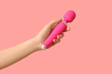 Woman with vibrator from sex shop on pink background
