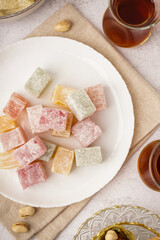 Plate with tasty Turkish Delight on light background