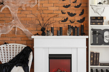 Interior of living room decorated for Halloween with fireplace, armchair and shelf unit