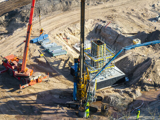 Active construction site in Riga, Latvia, featuring a red crane, drilling machine, scaffolding,...