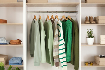 Big wardrobe with different stylish clothes and accessories in dressing room
