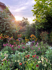A Captivating Vibrant Garden at Sunset, Delightfully Surrounded by Colorful Flowers in Bloom