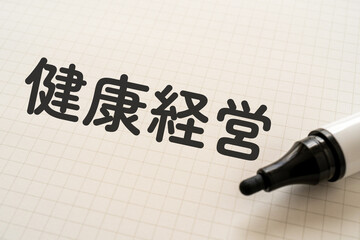 健康経営と書かれたノートとマーカー