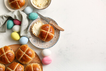 Plates with Easter cross buns, butter and eggs on white grunge background