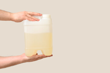 Male hands holding canister on grey background