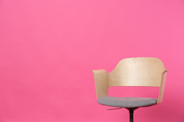 Comfortable office chair on pink background, space for text