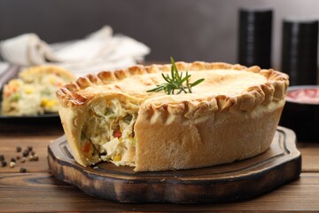 Delicious fresh homemade pie with rosemary on wooden table, closeup