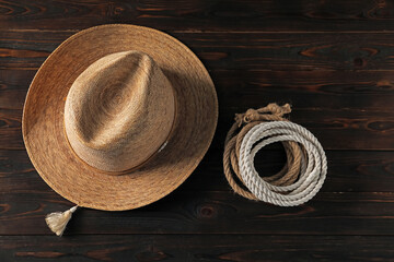 Cotton ropes and straw hat on dark wooden background, flat lay