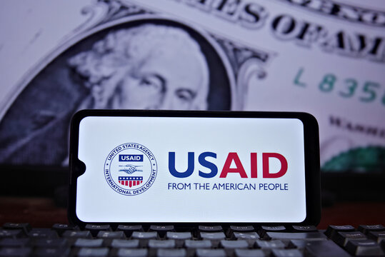 United States Agency for International Development (USAID) logo on the cell phone screen horizontally and the US dollar in the background. Rio de Janeiro, Brazil: 04.10.2025