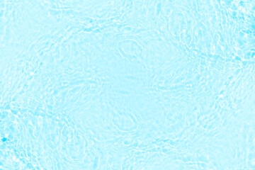 Blue water with ripples on the surface. Defocus blurred transparent blue colored clear calm water surface texture with splashes and bubbles. Water waves with shining pattern texture background.
