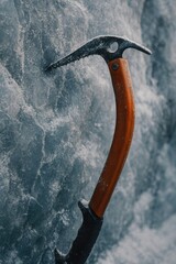 Ice axe embedded in a frozen surface, showcasing outdoor adventure tools.