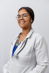Medical concept of beautiful Brazilian female doctor in white coat with stethoscope, waist up....