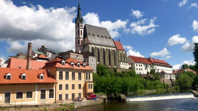 Church on a hill with surrounding buildings, trees and a river. European town on a summers day. Cesky Krumlov, Czech Republic. Europe.