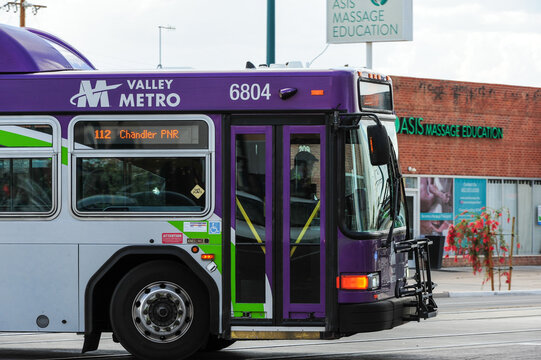 Valley Metro public transit bus on Route 112 to Chandler PNR travels through a commercial area, illustrating regional bus service, urban mobility, and public transportation infrastructure