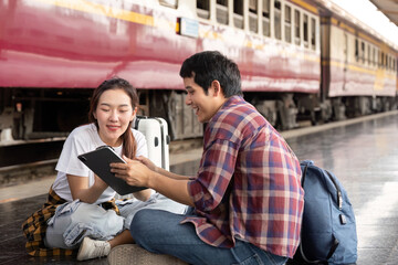 Journey and Travel. A couple planning their next adventure while waiting at the train station.