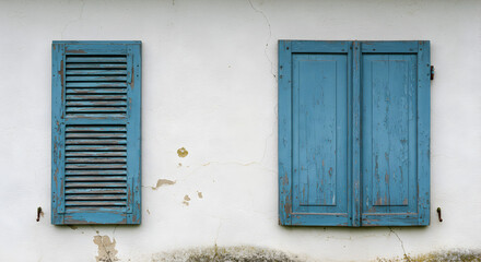 Fototapeta premium Rustic Charm Weathered Blue Shutters On Farmhouse Wall Adobe Stock
