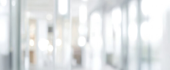 Blurred image of a bright white interior space with glass panels or windows. Blurred interior view of a bright modern office space with glass walls.