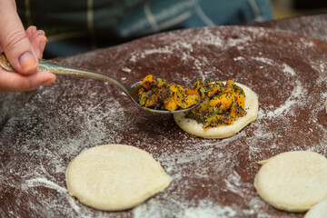 Hands of a Jewish woman begin triangular gomentashi with sweet filling