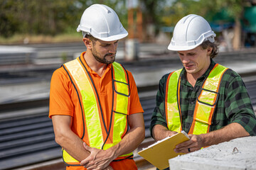 Two male engineers from different cultures work together in a floor making factory. Senior...