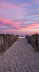Obraz premium Sandy Beach Path with Wooden Fence Leading Through Dunes to Ocean Under Vibrant Pink Sunset Sky