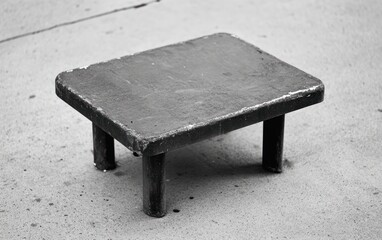 Small Weathered Gray Table on Asphalt