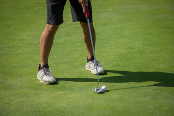 Close up of a golfer putting on a practice green