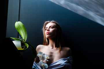 Sensual model portrait. Sexy portrait of tender beauty woman with orchid. Passionate model. Sensual...