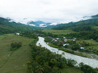 Aerial view of a river crossing a remote village in Indonesia