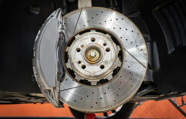 Car ventilated front brake disc with caliper. Modern brake disc with ventilation holes and cooling....