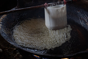 The process of making roti jala or keukarah which is a traditional cake that resembles a bird's nest. The process of making a unique traditional cakes in India and Asia