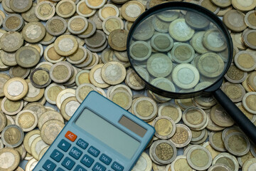 Detailed image of a calculator and magnifying glass highlighting Colombian 1000 and 500 pesos...