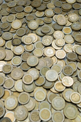 Detailed image of a large quantity of Colombian 1000 and 500 pesos coins, illustrating the richness...
