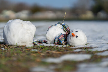 End of winter, hello spring. Winter snowman disappearing in early spring. Winter and spring seasons...