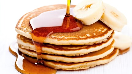Stack of pancakes with syrup and banana slices
