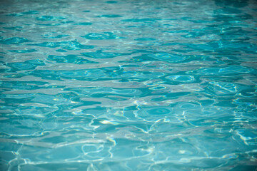 Fototapeta premium Background of blue water in swimming pool with sun reflection, ripple water wave in pool. Clear water background.