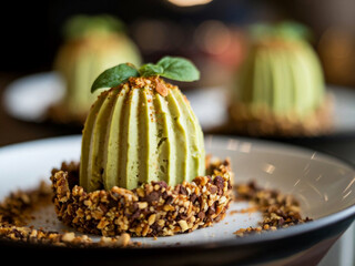 Green tea ice cream in nut tart shell with raspberry topping and mint leaves on black background for food menu