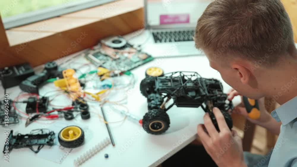 Poster top view of happy student study car model construction at table with electronic equipment and laptop