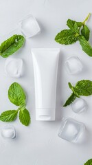 Obraz premium Minimalistic Composition of White Tube Surrounded by Fresh Mint Leaves and Ice Cubes on Gray Background
