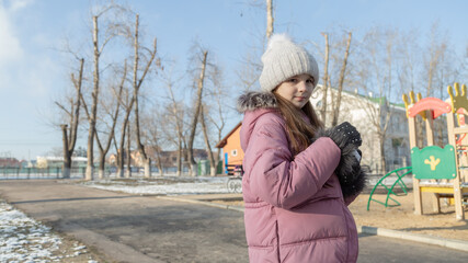 little girl playing on the playground on a winter day