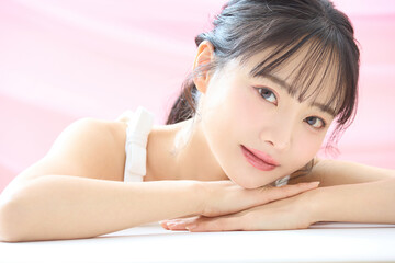 Obraz premium ピンク背景で撮影をした若い女性の爽やかな美容イメージ