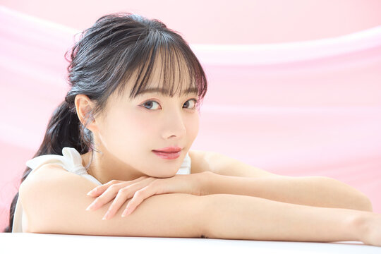 ピンク背景で撮影をした若い女性の爽やかな美容イメージ