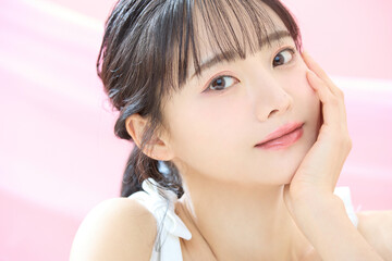 ピンク背景で撮影をした若い女性の爽やかな美容イメージ