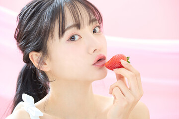 ピンク背景で撮影をした若い女性の爽やかな美容イメージ