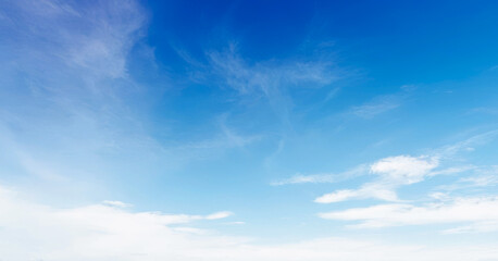 Obraz premium Clear blue sky with wispy clouds on a sunny day. Clean photo of blue sky during the day, Premium background for banner and wallpaper.