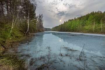 A lake with a cloudy sky in the background