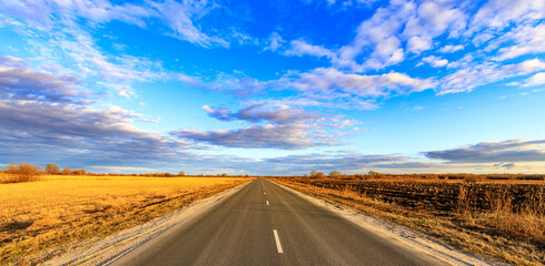 A long road with a clear blue sky above it