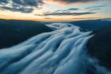 Fototapeta premium Clouds cascade over mountain valleys during sunset in breathtaking aerial hyper lapse, Aerial hyper lapse of of the clouds flowing through a mountain pass in Norway