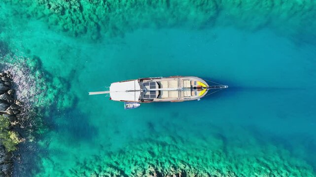 Aerial view of Gulet ship navigating the coastline under a blue sky