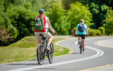 Fototapeta premium Cyclists ride on the bike path in the city Park 